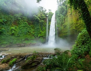 Towering Waterfall Crashing Into a Deep Basin Below, Surrounded by Lush Greenery and Mist Rising From the Water, Creating a Cool, Refreshing Scene in the Heart of the Rainforest