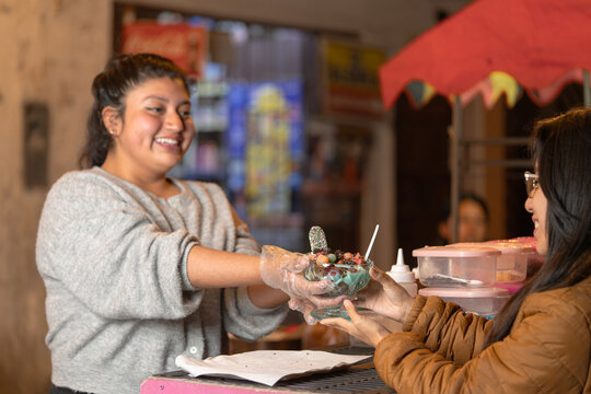 Street vendor serving dessert to customer at night market