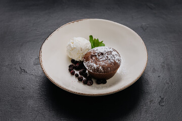 Decadent chocolate lava cake with vanilla ice cream, berries, and mint on a rustic plate