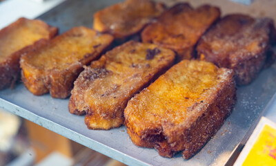 Traditional Easter croutons of Spanish cuisine Torrija, laid out on the counter for sale