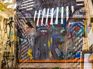 double exposure of street with gate with graffiti