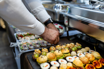 An elegant display of exquisite hors d'oeuvres at a formal event setting in the evening, featuring a variety of colorful finger foods