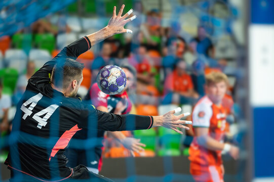 Handball goalkeeper and ball flying to the goal during handball game.