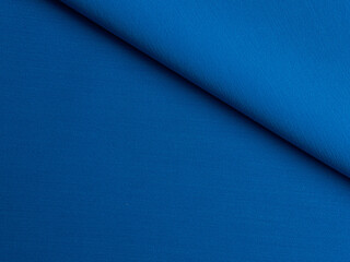 Blue fabric lies in beautiful folds. High-quality texture of blue fabric.