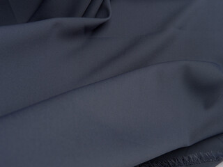Dark Gray fabric lies in beautiful folds. High-quality texture of dark gray fabric.
