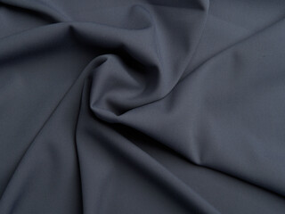 Dark Gray fabric lies in beautiful folds. High-quality texture of dark gray fabric.