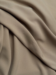 Beautiful folds of beige fabric. High-quality texture of beige fabric.