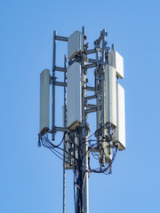 Multiple antennas and electronic equipment are installed on a telecommunication tower, enabling wireless communication under a clear blue sky