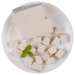 Blocks of tofu with some diced tofu on a white plate isolated transparent