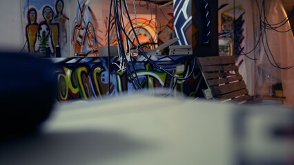 Empty messy criminals base of operations with graffiti drawings sprayed on walls. Electric cables hanging in derelict ghetto hideout used by vandals to commit illegal activities.