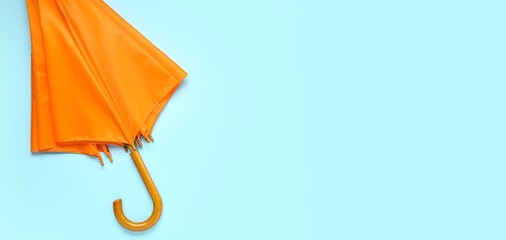 Stylish umbrella on light blue background with space for text, top view