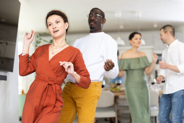 Modern dances performed by men and women of different nationalities at a holiday party at home