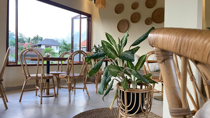 Experience the bohemian charm of this café with its rattan furniture, arched doorways, and earthy tones. A tranquil and inviting café with natural light, wooden furniture, and lush greenery. 