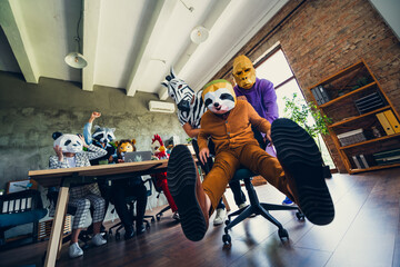 Portrait of panda rooster gorilla lion zebra raccoon mask business people push sloth chair loft...