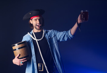 Young pirate with alcohol on dark background