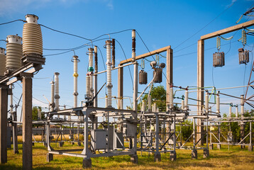Summer. Electrical substation against the sky with clouds. In the frame insulators, transformer,...