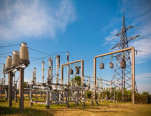 Summer. Electrical substation against the sky with clouds. In the frame insulators, transformer,...