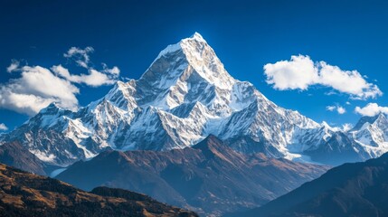 Obraz premium Majestic Snow-Capped Mountain Peak with Blue Sky and Clouds