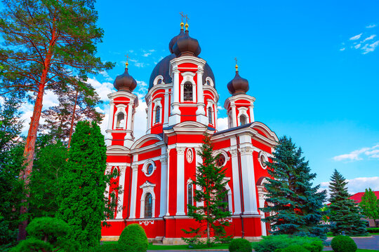 Curchi Monastery from Moldova. Red and white church stands prominently against a clear blue sky