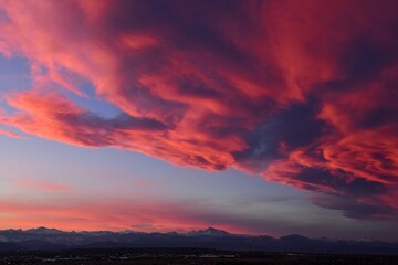 dramatic front of clouds moving in  across long's peak and the front range of the colorado rocky mountains  at sunset in winter, as seen from broomfield, colorado 