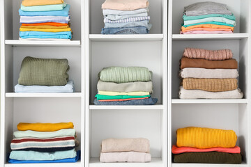 Clothes on shelves in interior of dressing room. Closeup