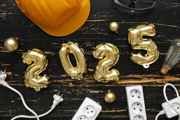 Figure 2025 with electrician's items and Christmas balls on dark wooden background