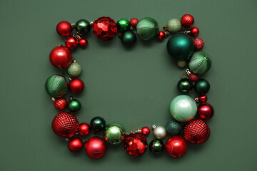 Frame made of different Christmas balls on green background