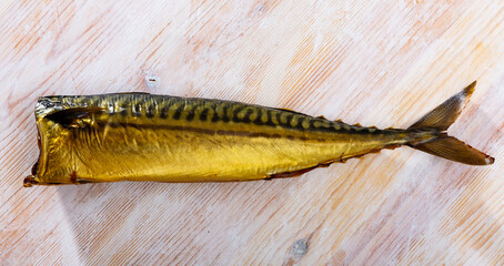 Fragrant smoked mackerel on wooden background. Traditional product of Russian cuisine