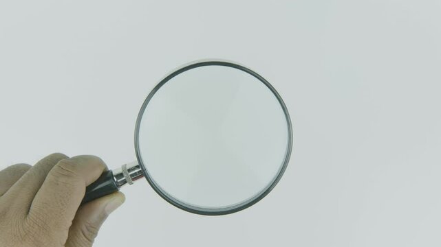 Left Hand Holding Magnifying Glass on White Background
