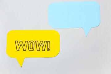 Paper speech bubbles with word WOW on grey background