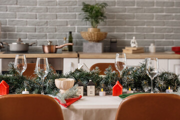 Beautiful table setting with Christmas decorations and fir branches in kitchen, closeup