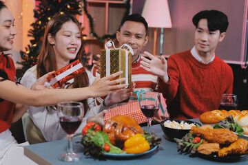 Friends opening Christmas gifts in living room