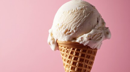 Ice cream served in a waffle cone against a pink backdrop