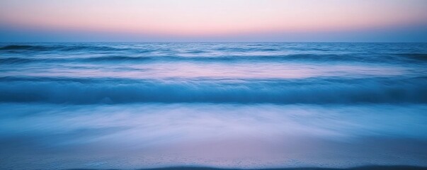 Obraz premium Serene ocean waves at dusk, blending soft colors in a tranquil coastal scene.