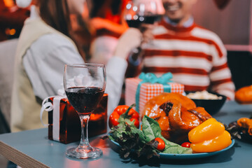 Group of happy Asian friends celebrating Christmas and decorate the Christmas tree indoors. Beauty woman with Christmas Gifts. New Year party. Woman hands decorate Christmas tree red ball, bauble.