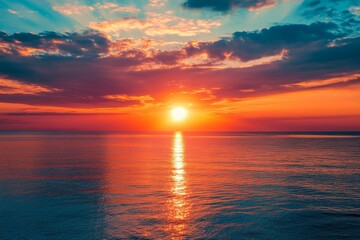 A vibrant sunset casts a fiery glow over a tranquil ocean.