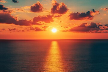 Obraz premium A fiery sunset over a vast expanse of ocean.