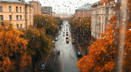 Rain drops on a window overlooking a city street with autumn leaves.