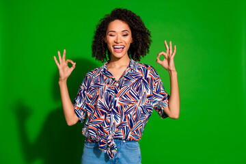 Photo of girlish lovely lady dressed print shirt winking eye showing two okey signs isolated green...