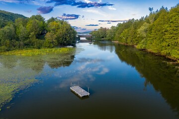 Swimming pontoon in the calm lake of Fitch Bay, surrounded by forest, Magog, Quebec, Canada.