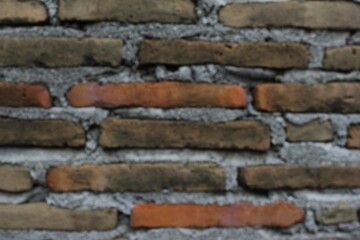 Out of focus from the background of the brick building wall. An old building with cement-coated bricks in an unfocused image.