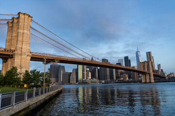 Fototapeta premium Brooklyn bridge to Manhattan. Urban architecture of New York city. Brooklyn bridge of New York city. Brooklyn landmark. Manhattan cityscape with skyscraper architecture. Hudsson river