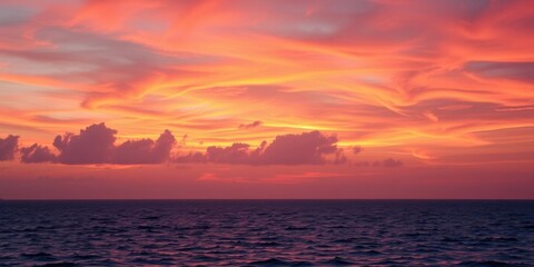 Fototapeta premium Vibrant orange and pink hues paint the sky over a calm ocean at sunset, water, pink
