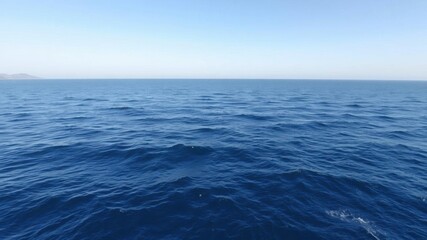 Obraz premium A tranquil background of a vast ocean, with gentle waves and a clear blue sky overhead, peacefulness, ocean