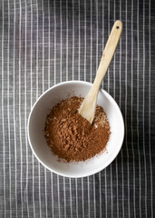 Cocoa Powder with Wooden Spoon in Bowl, mixing dry ingredients for no bake cookies