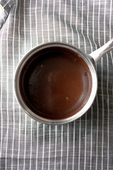 Smooth Melted Chocolate in Saucepan on Striped drying towel, Dark Chocolate