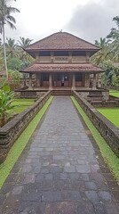 A traditional building surrounded by lush greenery and a stone pathway.