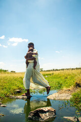 Obraz premium A young African mother playing with her baby outdoors.