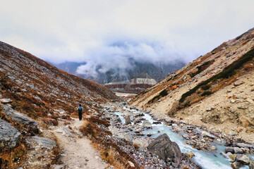 Rocky mountain trail rises over rocky glacial terrain following the Hinku river up to Khare village on route to the  Base camp of Mera Peak,a 6476 meter high peak in the Khumbu Himalayas,Nepal