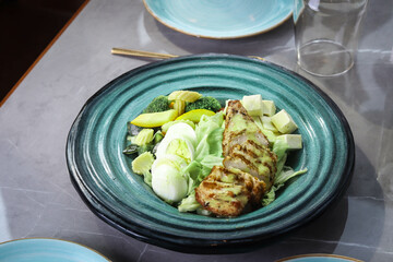 close-up of a vibrant, healthy salad, featuring grilled chicken breasts atop a bed of fresh, colorful vegetabl
